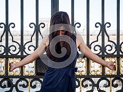 Beatiful brunette woman crucified on a palace's gate Stock Photo