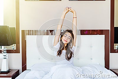 Beatiful brunette woman stretching in bed after wake up. Starting new day Stock Photo