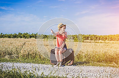 Beatiful girl doing hitchhiking on the road Stock Photo