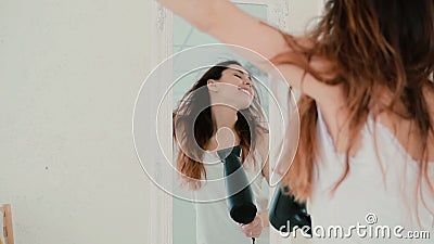 Beau sentiment de jeune femme heureux et chantant tout en employant le hairdryer Le vent gonfle des cheveux Mouvement lent clips vidéos Beau sentiment de jeune femme heureux et chantant tout en employant le hairdryer Le vent gonfle des cheveux Mouvement lent clips vidéos
