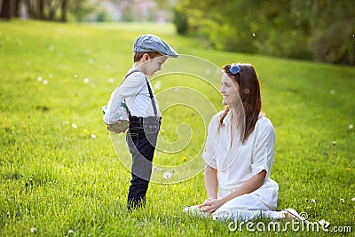 Beautful kid and mom in spring park, flower and present Stock Photo