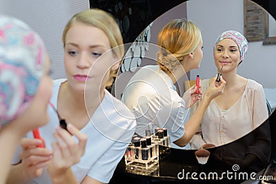 Beautician applying lip gloss to client Stock Photo