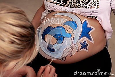 Bodypaint on a pregnant woman's belly Stock Photo