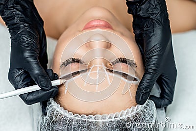 Beautician doing tattooing eyebrow during permanent make up Stock Photo