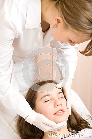 Beautician explored face of young women Stock Photo