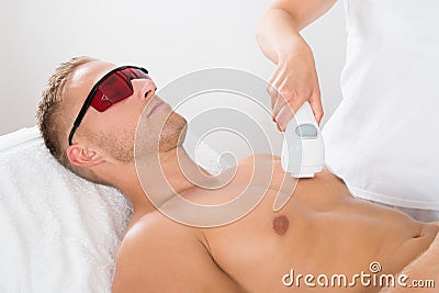 Beautician Giving Laser Epilation On Man's Chest Stock Photo