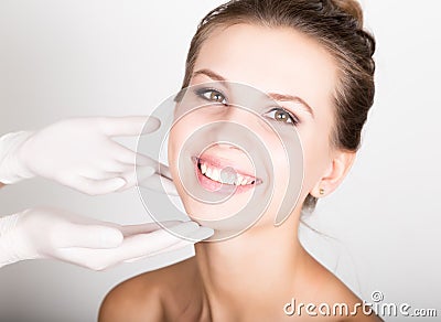 Beautician hand`s examining beautiful young female face. Stock Photo