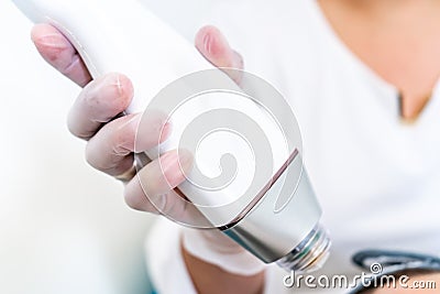 Beautician holding radio frequency microneedling hand piece. Used for skin tightening and cosmetic treatments in spas, salons and Stock Photo