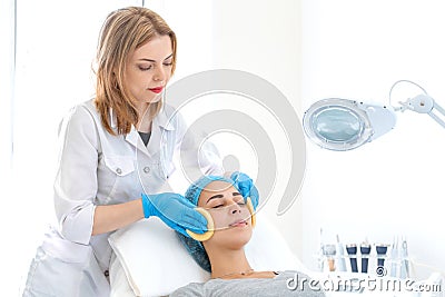 Beautician makes client facial massage sponges. Moisturizing, cleaning and facial skin care. Cosmetic procedures Stock Photo