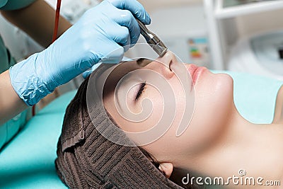 Beautician makes mechanical cleaning of face. Procedure of Microdermabrasion, diamond grinding. Stock Photo