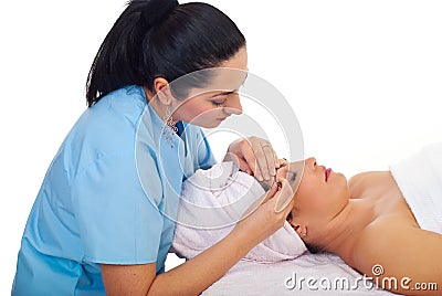 Beautician plucking woman eyebrow Stock Photo