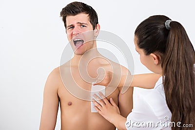 Beautician Waxing Man's Chest In Beauty Center Stock Photo