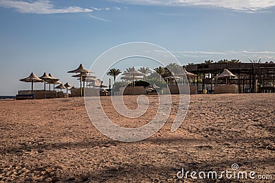 Beautiful abandoned beach. Umbrellas and sunbeds on the beach. Stock Photo