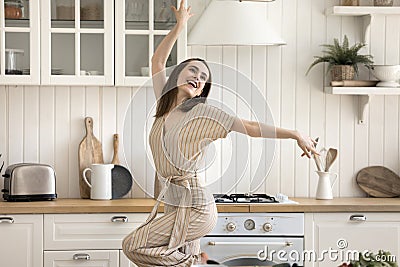Beautiful active woman enjoy life, dancing alone in cozy kitchen Stock Photo