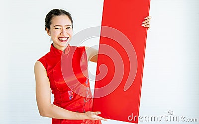 Beautiful adult Asian Chinese woman wearing red traditional dress, posing, holding blank sign to celebrate New Year, standing on Stock Photo