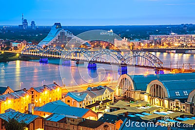 Beautiful aerial panorama of Riga. Railroad bridge over Daugava river and National library during amazing sunset. View of illumina Editorial Stock Photo