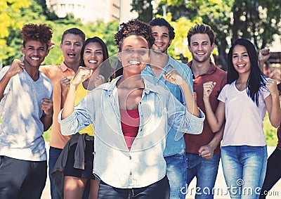 Beautiful african american female student with group of cheering young adults Stock Photo