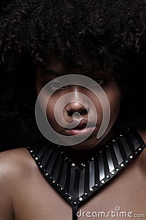 Beautiful african american nacked woman with curly hairstyle wearing leather necklace with metal inserts Stock Photo