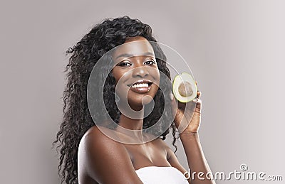 Beautiful african american woman holding avocado half Stock Photo