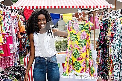 Beautiful african american woman selling clothes at market Stock Photo