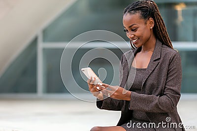 Beautiful african business woman at the office using smartphone technology, 5g, 4g, LTE, broadband internet Stock Photo