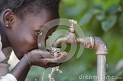 Beautiful African Child Drinking from a Tap Water Scarcity Symbol Stock Photo