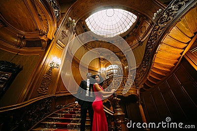Beautiful african couple posing on the vintage stairs. Luxurious theatre interior background Stock Photo
