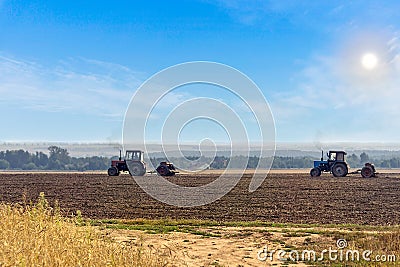 Beautiful agricultural landscape with two old tractors equipped with seeders. Stock Photo