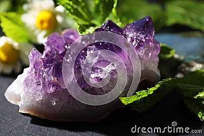 Beautiful amethyst and camomile flowers on table. Healing crystal Stock Photo