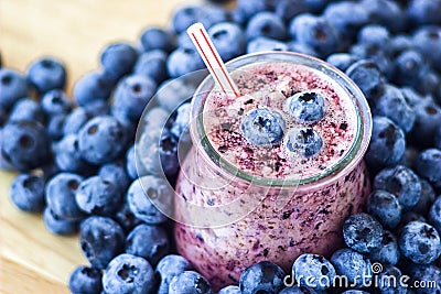 Beautiful appetizer blueberry fruit smoothie milk shake glass jar with juicy fresh berries background top view Yogurt cocktail Nat Stock Photo