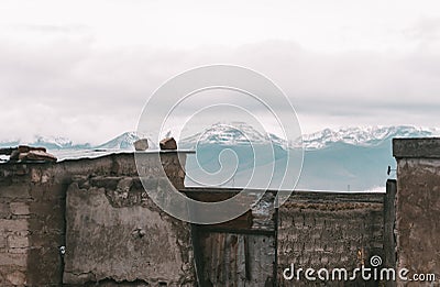 Beautiful arid landscape with rustic construction, snowy mountains and cloudy sky in Peruvian Altiplano near Colca Canyon, Peru Stock Photo