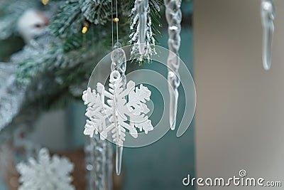 Beautiful artificial fir tree branches with snowflakes and icycles toys. Merry Christmas Happy New Year decorative elements. Stock Photo