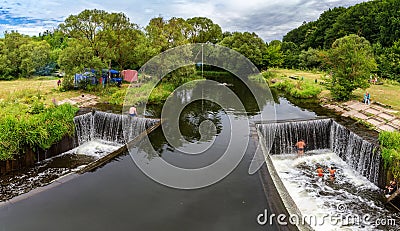 A beautiful artificial waterfall for swimming in the summer in the city of Satanov Editorial Stock Photo