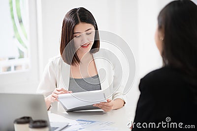 Beautiful asian business woman is reading the resume and gives the interview as a human resource for company recruitment with an Stock Photo