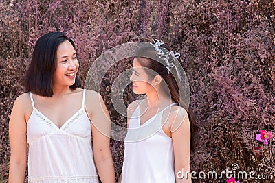 Beautiful Asian couple with wedding dress LGBT women spent time together in park homosexual announcement relationship for social Stock Photo