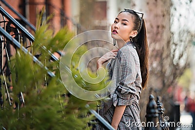 Beautiful asian fashionable young woman posing on city street outdoors. Stock Photo