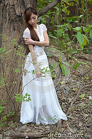 Beautiful Asian girl leaned against the tree Stock Photo