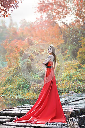 Beautiful Asian girl in red dress frolicking in the countryside Stock Photo