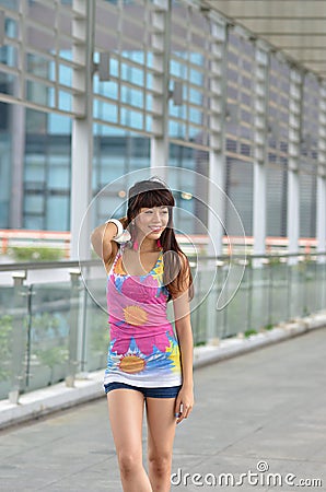 Beautiful Asian girl showing youthful vigor on the pedestrian bridge Stock Photo