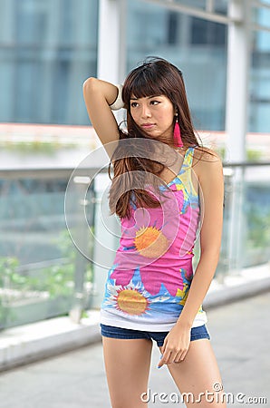 Beautiful Asian girl showing youthful vigor on the pedestrian bridge Stock Photo