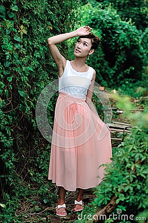 Beautiful Asian girl strolls in the plant wall Stock Photo