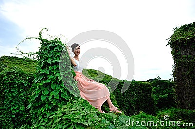 Beautiful Asian girl strolls in the plant wall Stock Photo