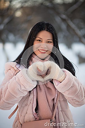 Beautiful Asian shows heart gesture sign for photocamera. Stock Photo
