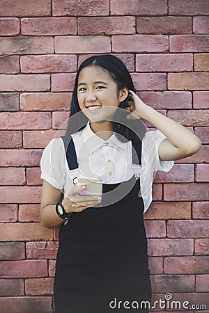 Beautiful asian teenager toothy smiling face using smarphone in Stock Photo