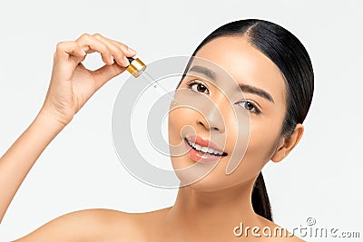 Beautiful Asian woman applying anti aging moisturizing serum on her face Stock Photo