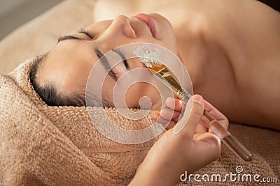 Beautiful Asian Woman getting facial nourishing at spa salon. Stock Photo