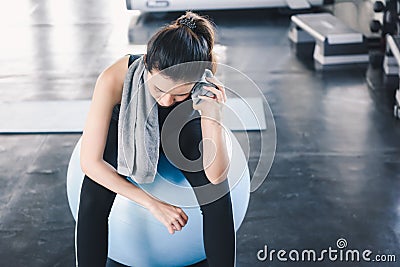 Beautiful Athletic Woman is Wiping Sweat With Towel After Exercised in Gym, Portrait of Pretty girl in Sportswear is Exercising in Stock Photo