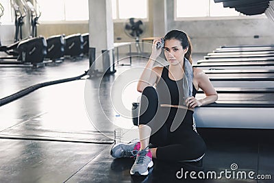 Beautiful Athletic Woman is Wiping Sweat With Towel After Exercised in Gym, Portrait of Pretty Girl in Sportswear is Exercising in Stock Photo