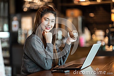 Beautiful Attractive Business Asian woman working with laptop and looking in monitor smile and have positive emotional Stock Photo