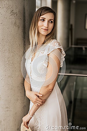 Beautiful attractive woman wearing white dress indoor Stock Photo